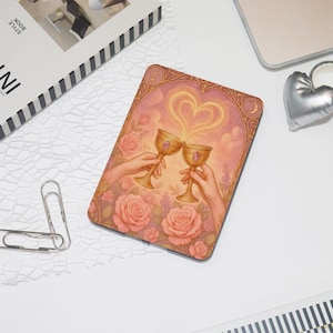 May include: A rectangular mousepad featuring a romantic illustration. Two hands raise golden chalices, with a heart-shaped light emanating from them. The background is a soft pink with roses and decorative borders.