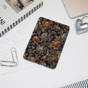 May include: A dark blue laptop sleeve with a floral pattern featuring gold and brown flowers on a black background.
