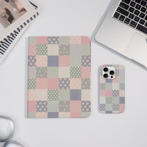 May include: A pastel-colored patchwork design covers a tablet case and a smartphone case. The pattern features squares of pink, green, and blue with floral and geometric motifs. A laptop and a book are in the background.