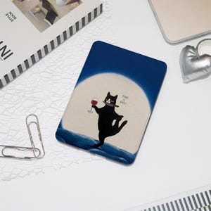 May include: A blue and beige tablet case featuring a black cat illustration. The cat holds a wine glass and a cigar, with the text "TAKE IT EASY". The case has a dark blue background with a white circle.