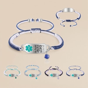 Pode incluir: Pulseiras de alerta médico com bandas de cordão tecido em várias cores, incluindo azul, branco e preto. Cada pulseira apresenta uma placa de metal com um símbolo médico, código QR e o texto "SCAN ME". Algumas têm um pequeno pingente.