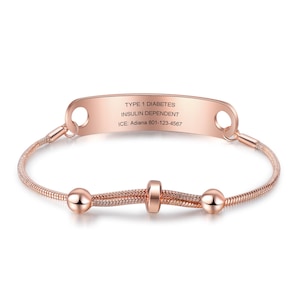 May include: Rose gold medical ID bracelet with the text "TYPE 1 DIABETES INSULIN DEPENDENT" and emergency contact information. The bracelet features a snake chain design with decorative beads.