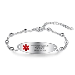 May include: A silver-toned medical alert bracelet. The oval-shaped plate has the red Star of Life symbol and the words "DIABETES INSULIN WARFARIN PENICILLINP" in black. The bracelet features a chain with small, round beads.