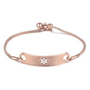 May include: Rose gold medical alert bracelet with a textured ID plate. The plate features a white medical symbol. The bracelet has a snake chain design and an adjustable clasp.