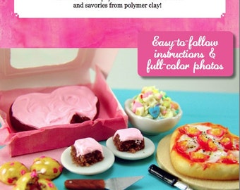 Puede incluir: Un pastel en forma de corazón rosa y blanco, dos pasteles de chocolate con glaseado rosa, una pizza con salsa roja y queso, y un tazón de caramelos coloridos. La imagen se titula "Dollhouse Miniature Valentine's Day Foods" y "Cooking School Series, vol. 2".