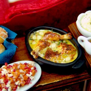 Puede incluir: Una mesa puesta con una variedad de platos, incluyendo una fuente para hornear con pollo y patatas, un bol de pur&eacute; de patatas, una salsera, un bol de ensalada de fruta y una cesta de panecillos.