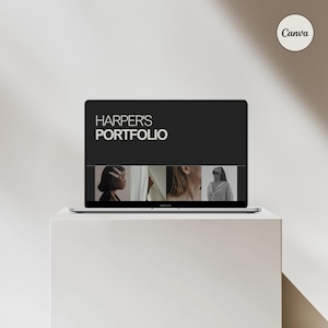 May include: A laptop computer displaying a portfolio website with the text "HARPER'S PORTFOLIO" and images of people. The laptop is on a white surface.