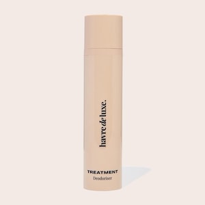 Könnte beinhalten: Eine zylindrische, beige Sprühflasche mit passendem Deckel. Die Flasche trägt den vertikal aufgedruckten schwarzen Schriftzug "havre de luxe." sowie die Wörter "TREATMENT" und "Deodoriser" in schwarzer Schrift am unteren Rand.
