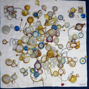 May include: A white silk scarf with a navy blue border, featuring a scattered pattern of antique pocket watches in gold, silver, and various colors. The watches are connected by chains and have intricate details.