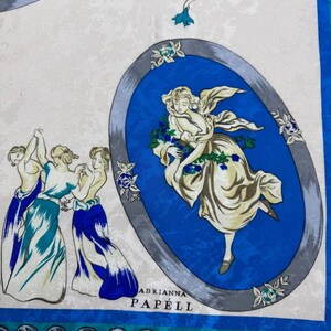 May include: A square silk scarf with a repeating pattern of classical figures in blue, white, and teal. The scarf features oval medallions with dancing figures and floral accents. The text "ADRIANNA PAP&Eacute;LL" is printed on the scarf.
