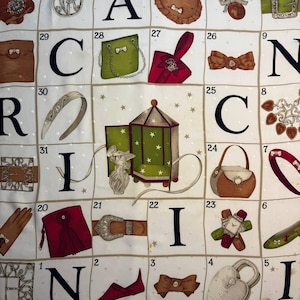 May include: A white fabric with a grid pattern featuring various fashion accessories and the letters of the word "CANCI". The accessories include handbags, bows, belts, and a perfume bottle. The fabric has a dotted background and the brand name "Nina Ricci".