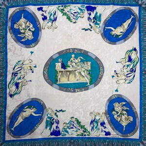 May include: Square silk scarf with a cream background and a blue border. The scarf features oval medallions with classical figures in blue and white, and a central oval with a detailed scene.