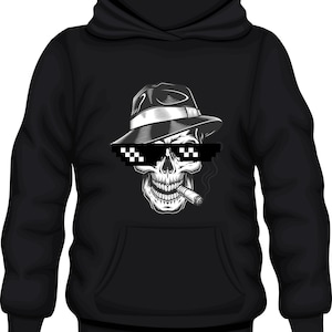 Può includere: Felpa nera con un teschio bianco che indossa un fedora e occhiali da sole. Il teschio fuma una sigaretta.