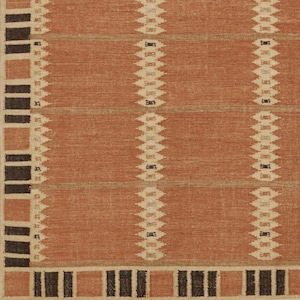 May include: A terracotta-coloured rug with a geometric pattern. It features vertical rows of diamond shapes in off-white and black against a warm, earthy background. The border has alternating squares and rectangles in beige, terracotta, and black.