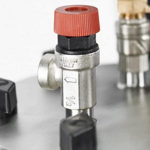 May include: A metallic pressure relief valve with a red plastic cap, featuring the text MADE IN ITALY and a 1/2 inch marking. The valve is mounted on a circular stainless steel plate alongside a brass fitting with a red handle and black knobs.