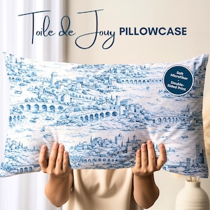 May include: A rectangular pillowcase with a blue and white Toile de Jouy design. The pillowcase features a detailed landscape scene with buildings, bridges, and boats. The text "PILLOWCASE" is visible.