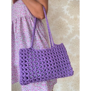 May include: A purple crocheted tote bag with a wide, open top and thick straps. The bag is made with a simple, open stitch pattern.