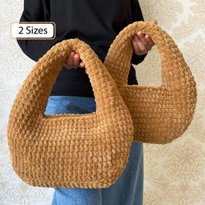 May include: Two brown, textured, crochet handbags with rounded handles. The bags are held up against a patterned background. The text "2 Sizes" is in a white box in the upper left corner.