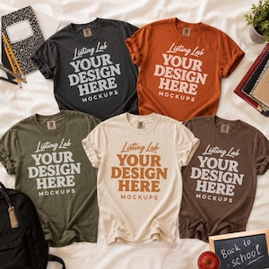 May include: Five short-sleeved crew neck t-shirts in charcoal, burnt orange, olive green, cream, and dark brown. Each shirt features the printed text Listing Lab YOUR DESIGN HERE MOCKUPS in a bold, retro-style font centered on the chest area.