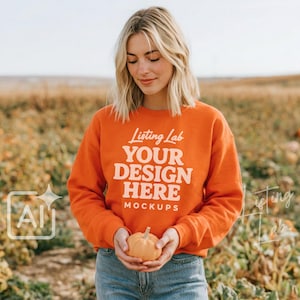 Könnte beinhalten: Ein leuchtend orangefarbenes Langarm-Sweatshirt mit dem weißen Schriftzug Listing Lab YOUR DESIGN HERE MOCKUPS auf der Vorderseite. Das Sweatshirt hat einen Rundhalsausschnitt und gerippte Bündchen und wird zu einer blauen Jeans getragen.