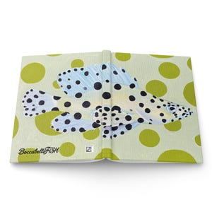 May include: A hardcover book featuring a light green cover with a pattern of large olive green polka dots. The center displays a painting of a white fish with black spots and light blue fins. The text BoccabelloFiSH is printed in black.