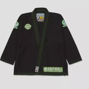 May include: Black and green Jiu-Jitsu gi with the text "Shoyorroll Premium Jiu-Jitsu Kimonos" on the bottom right corner.