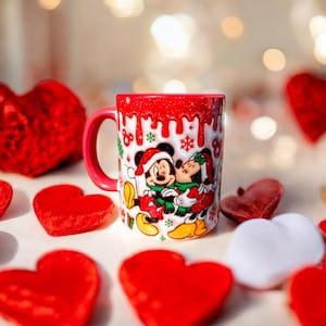 May include: Red and white ceramic mug with a Christmas-themed design featuring Mickey Mouse and Minnie Mouse kissing. The mug has a white background with red and green accents. The mug is surrounded by red hearts.