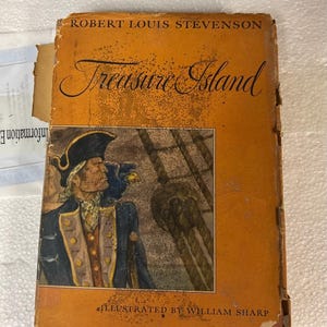 May include: A vintage hardcover book titled Treasure Island by Robert Louis Stevenson. The orange dust jacket features a central illustration of a pirate in a blue coat and tricorn hat, with the text Illustrated by William Sharp at the bottom.