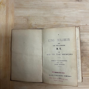 Puede incluir: Un libro abierto con p&aacute;ginas amarillentas. El t&iacute;tulo es "KING SOLOMON AND HIS FOLLOWERS" con "N.Y." y "AID TO THE MEMORY" debajo. Publicado por Allen Publishing Company, Brooklyn, NY.
