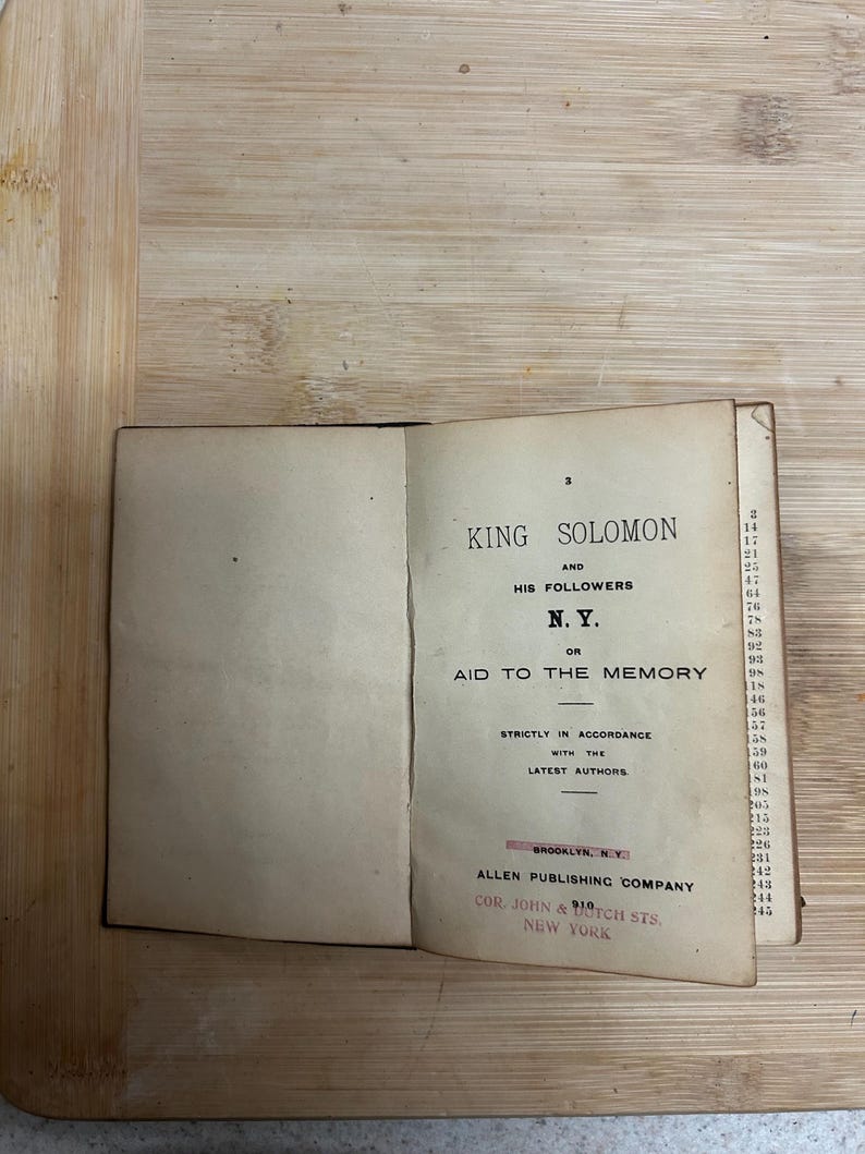 Puede incluir: Un libro abierto con p&aacute;ginas amarillentas. El t&iacute;tulo es "KING SOLOMON AND HIS FOLLOWERS" con "N.Y." y "AID TO THE MEMORY" debajo. Publicado por Allen Publishing Company, Brooklyn, NY.