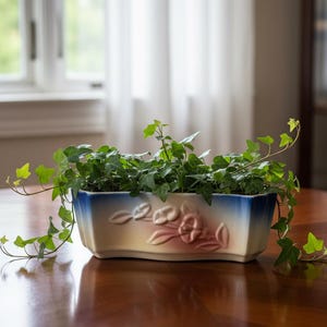 May include: A rectangular ceramic planter with a blue and cream gradient, adorned with embossed floral designs. The planter is filled with green ivy, its vines cascading over the edges. The planter sits on a wooden table.