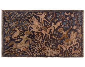 Puede incluir: Una alfombra rectangular con fondo azul oscuro y un diseño detallado con figuras a caballo, animales y follaje en beige, marrón y azul. La alfombra tiene un borde con flecos.