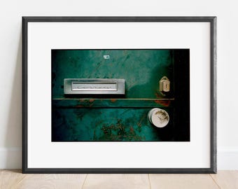 May include: A close-up of a weathered green metal door with a silver mailbox that says "Correa" and a silver door knob.