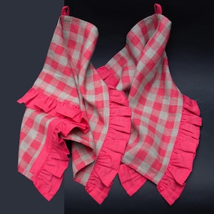 May include: Two pink and white gingham kitchen towels with pink ruffled edges.