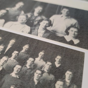 Op de afbeelding: Zwart-witfoto van een groep mensen, waarschijnlijk een klassenfoto. De mensen staan in rijen, met de langste achteraan en de kortste vooraan. De foto is licht wazig.
