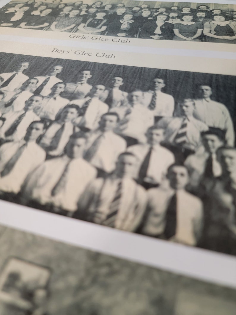 Op de afbeelding: Zwart-witfoto van een middelbare school zangkoor. De foto is verdeeld in twee secties, een voor het meisjeskoor en een voor het jongenskoor. Het meisjeskoor staat in een rij, terwijl het jongenskoor in een halve cirkel staat.