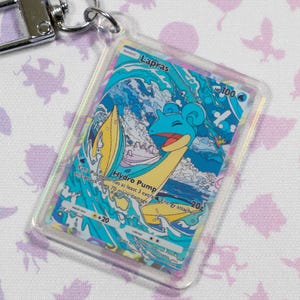 Llavero holográfico acrílico de carta Lapras Pokémon TCG Pocket en miniatura