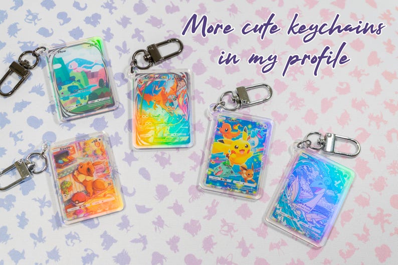 May include: Five iridescent keychains featuring Pokemon characters. The keychains are made of clear plastic with a holographic finish. The characters include Pikachu, Bulbasaur, Charmander, Squirtle, and Eevee. The text "More cute keychains in my profile" is written on the image.