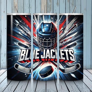 May include: A set of three stainless steel tumblers with a hockey theme. The design features a blue hockey helmet, crossed hockey sticks, and the words "BLUE JACKETS" in white and red. The background has a burst of red and blue lines.