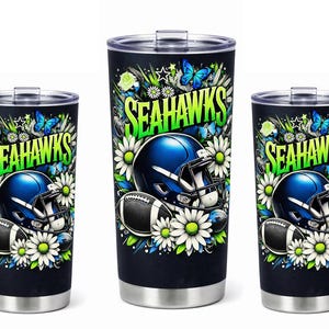 May include: Three stainless steel insulated tumblers featuring a design for the Seattle Seahawks. The design includes a blue football helmet, football, daisies, butterflies, and the team name in green and white.