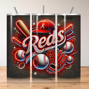 Puede incluir: Un conjunto de tres vasos de acero inoxidable con temática de béisbol. Los vasos presentan un diseño rojo, blanco y azul con la palabra "Reds" en una fuente audaz y estilizada. El diseño también incluye pelotas de béisbol, bates y un guante de béisbol.