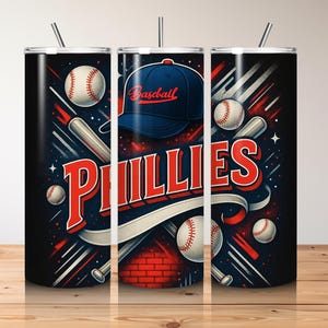 May include: A baseball-themed tumbler featuring the word "Phillies" in red and white, with a blue baseball cap and baseballs. The design includes baseball bats and a brick wall background, with a black background and red and white accents.
