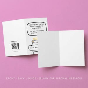 Peut inclure: Une carte de v&oelig;ux blanche avec une illustration de dessin anim&eacute; et du texte. La carte indique : &laquo; NOUS AVONS LA RELATION M&Egrave;RE-FILLE PARFAITE. TU ES MA M&Egrave;RE ET JE SUIS... TU ES BIEN ! &raquo; La carte est ouverte, r&eacute;v&eacute;lant un int&eacute;rieur vierge, avec un fond rose.