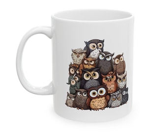 May include: White ceramic mug featuring a colourful illustration of a group of owls stacked on top of each other. The owls are various shades of brown, grey, and white.