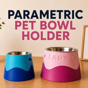 Op de afbeelding: Tweekleurige voerbak houders met roestvrijstalen kommen. Eén is blauw en turquoise, de andere is roze en magenta. De tekst "PARAMETRIC PET BOWL HOLDER" staat bovenaan. De roze kom heeft "LADY DI" erop.