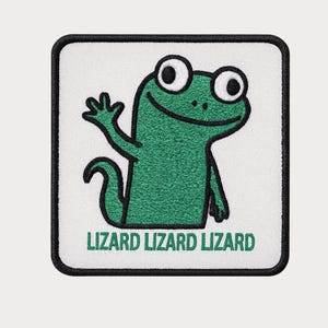 May include: Square patch with a green lizard waving, outlined in black, on a white background. The text "LIZARD LIZARD LIZARD" is printed in green below the lizard. The patch has a black border.