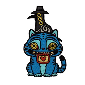May include: Embroidered patch featuring a blue cat-like creature with a wide grin and a heart-shaped design on its chest. A black bird wearing a hat sits atop the creature's head. The patch has yellow, black, and red accents.