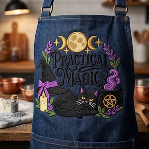May include: A dark blue denim apron featuring an embroidered design with the text Practical Magic. The embroidery includes a black cat, a witch hat with a purple bow, a candle, a cauldron with purple smoke, a moon, and lavender sprigs.
