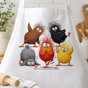 May include: A white apron featuring a colorful graphic of five cartoon birds with messy feathers. The birds are brown, black, gray, red, and yellow. The red bird stands on one leg on a mat with the text wobble printed near its foot.