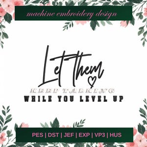 May include: Machine embroidery design featuring the text "Let them keep talking while you level up" in black with a pink heart. The design is surrounded by pink flowers and green leaves.